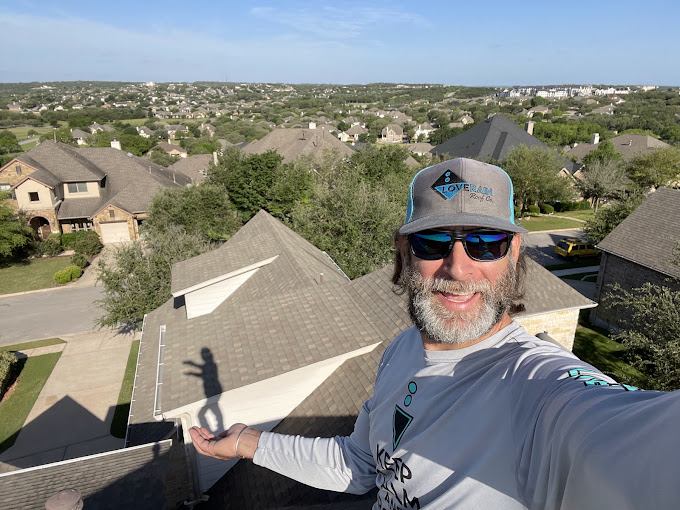 Jake inspecting a shingle roof above the neighborhood